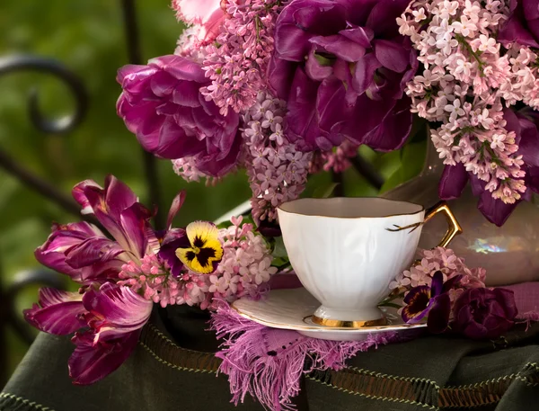 A cup of coffee and a bouquet of lilacs — Stock Photo, Image