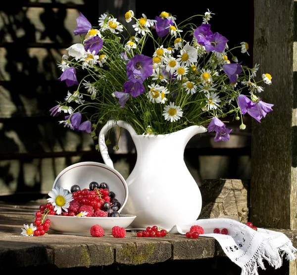 Zátiší s květinami a bobulemi — Stock fotografie