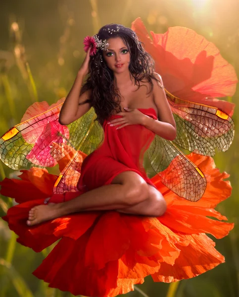 Brunette avec des ailes assises dans une fleur — Photo