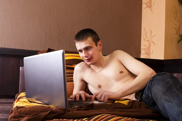 轻松的年轻人使用的便携式计算机 — 图库照片