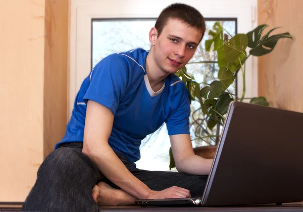 Ung man med bärbar dator — Stockfoto