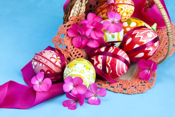Cesta cheia de ovos de Páscoa e flor — Fotografia de Stock