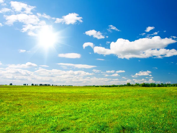 Groene heuvel onder blauw bewolkte hemel whit su — Stockfoto