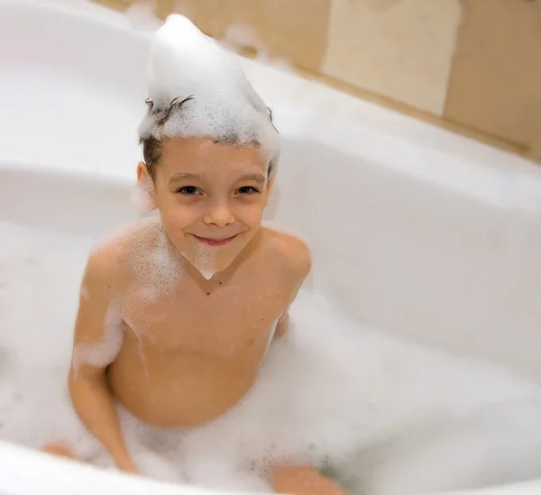 Glücklicher Junge badet in einem Badezimmer — Stockfoto