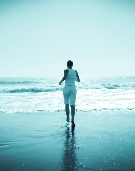 Mujer joven corriendo en la playa — Foto de Stock