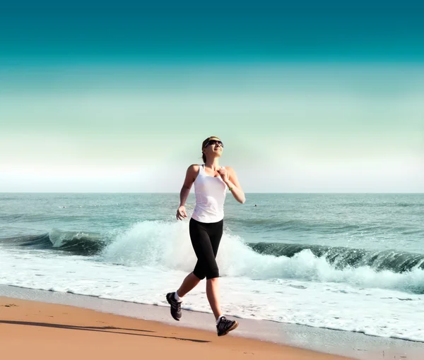 ビーチでジョギングする若い女性 — ストック写真