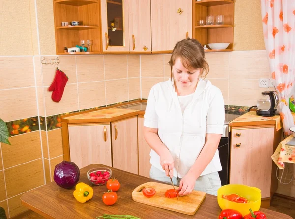 Gadis itu memotong tomat merah — Stok Foto
