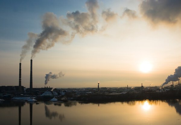 Smoke factory chimneys at sunset
