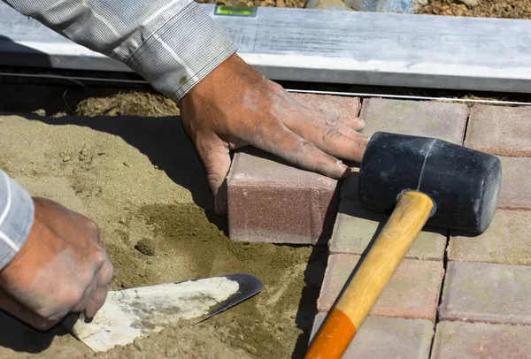Worker puts sidewalk tile — Stock Photo, Image