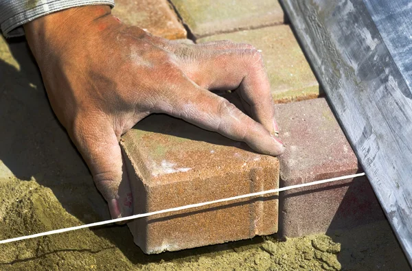 Worker puts sidewalk tile — Stock Photo, Image