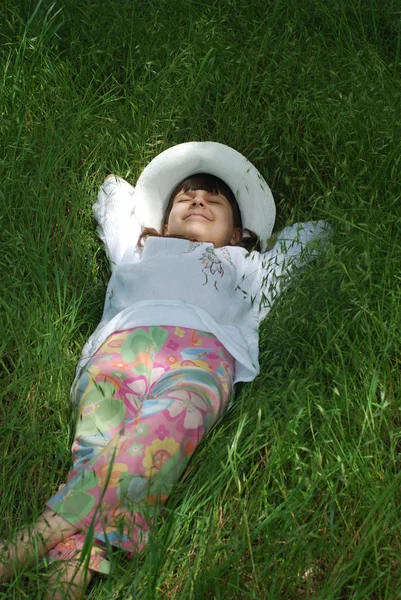 Dítě odpočinku na zelené trávě — Stock fotografie