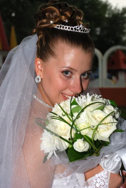 Ziemlich glückliche Braut mit Blumen lizenzfreie Stockbilder