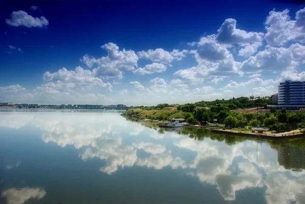 Cloudy blue sky reflection in calm water — Stock Photo, Image