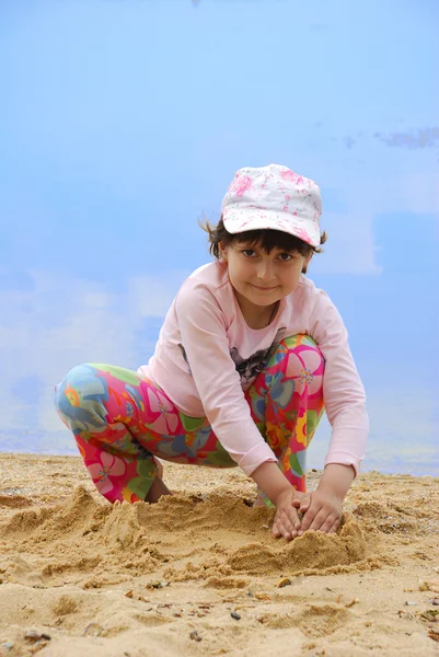 Дитина на березі річки грає в пісок — стокове фото