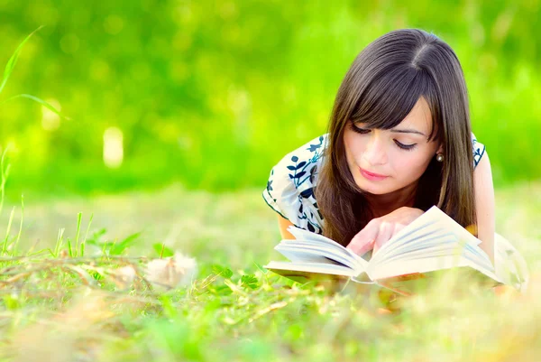 Menina lê livro no prado — Fotografia de Stock