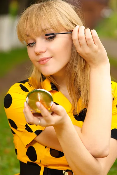 Blondin med spegeln och bläck för ögonfransar — Stockfoto