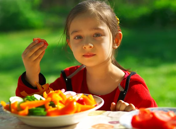 Дівчинка їсть овочі — стокове фото