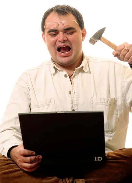 Mężczyzna wali młotem na laptopie — Zdjęcie stockowe