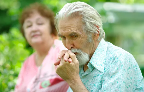 Starszy mężczyzna całuje rękę żony — Zdjęcie stockowe