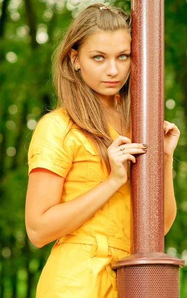 Girl in yellow at lamppost — Stock Photo, Image