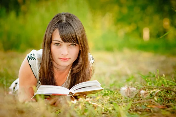 Chica lee libro en el prado —  Fotos de Stock