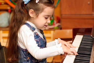 Girl plays piano clipart