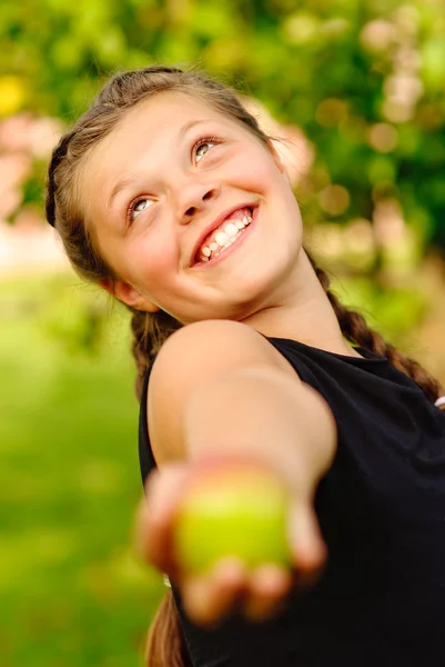 Riendo chica estira una manzana —  Fotos de Stock