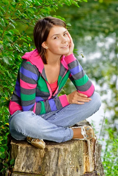 Девушка сидит на корешке — стоковое фото