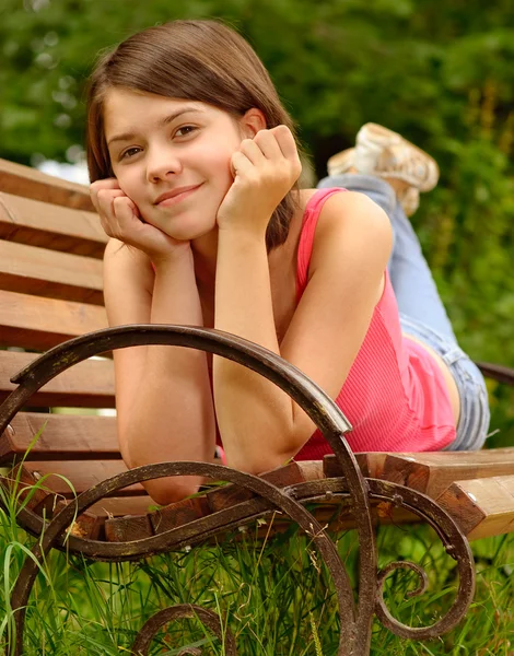 Девушка лежит на скамейке — стоковое фото