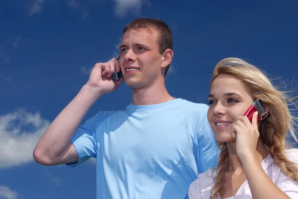 Дівчина і хлопець розмовляють по мобільному телефону — стокове фото