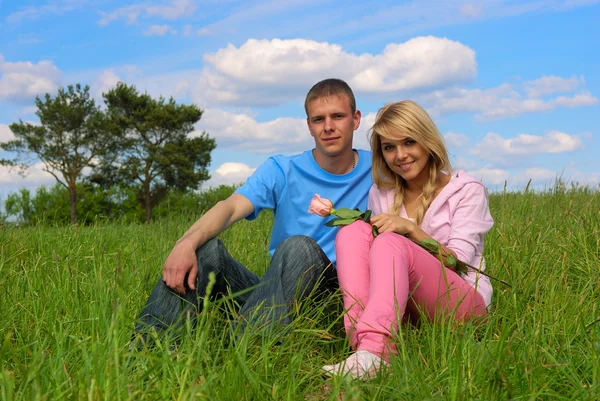 Genç adam ve kız bir çayır üzerinde — Stok fotoğraf