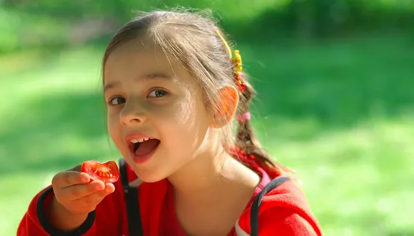 少女はトマトを食べる — ストック写真