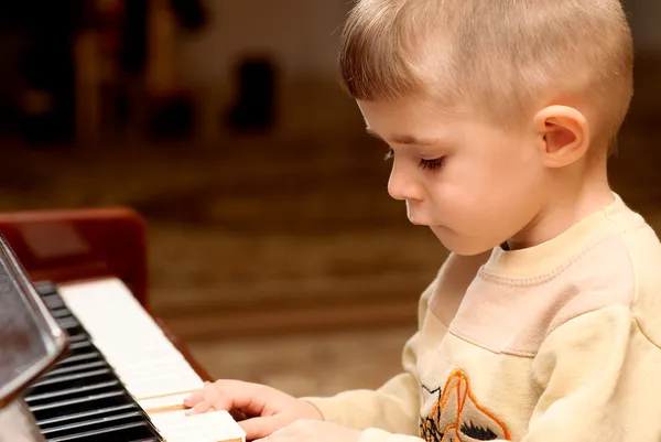 Menino toca piano — Fotografia de Stock