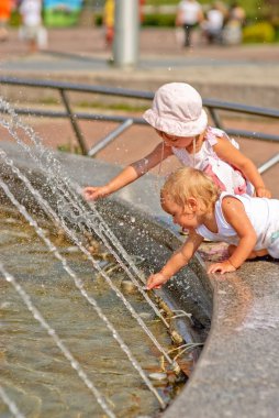Sisters play at fountain clipart