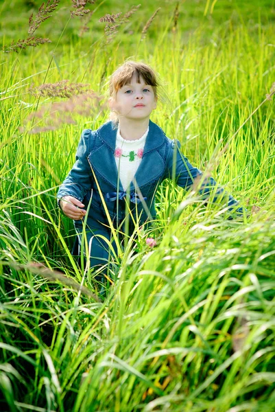 Meisje onder groen gras — Stockfoto