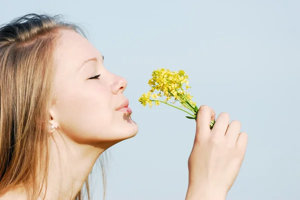 Das Mädchen riecht Blumen — Stockfoto