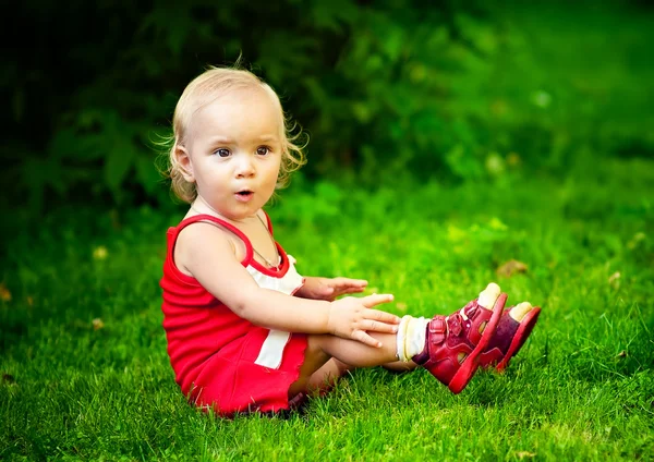 Baby gedaald om gras — Stockfoto