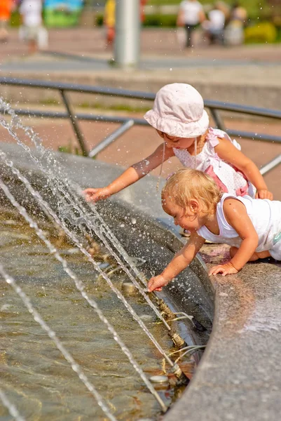 Сёстры играют у фонтана — стоковое фото