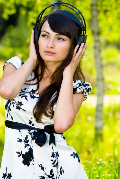 Menina em fones de ouvido na natureza — Fotografia de Stock
