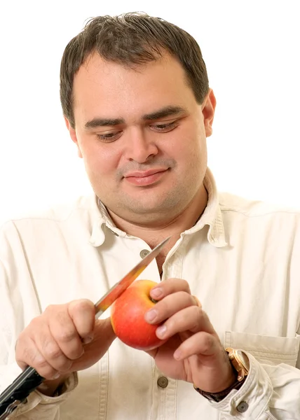 Чоловік вирізає яблуко — стокове фото