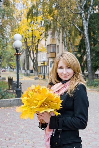 Blonde avec un bouquet de feuilles jaunes — Photo