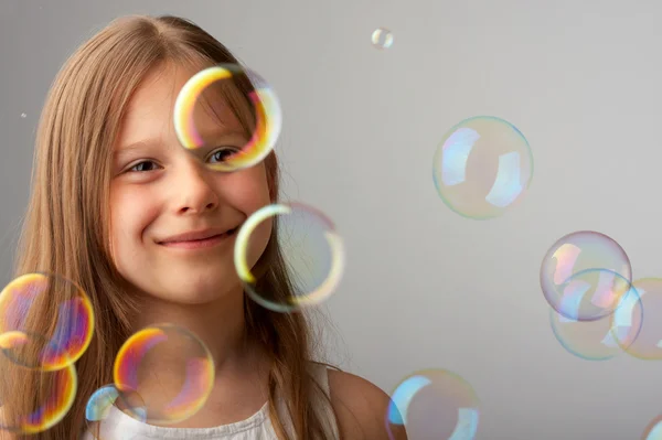 Счастливая девушка и летающие пузыри — стоковое фото