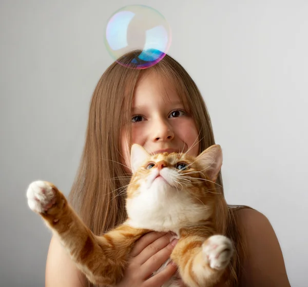 Liten flicka med en röd katt — Stockfoto