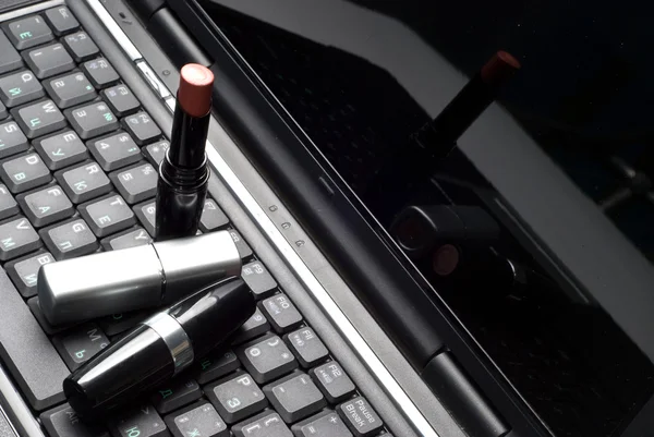 Three lipsticks on a laptop — Stock Photo, Image