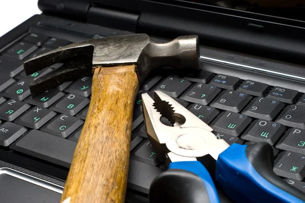 Hammer and pliers on a laptop — Stock Photo, Image