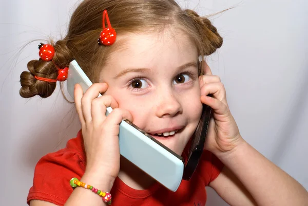 Küçük kız iki cep telefonlarında konuşma — Stok fotoğraf
