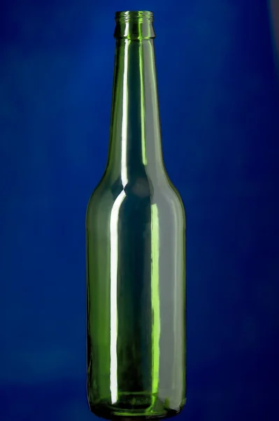 Zelená skleněná láhev na modré — Stock fotografie