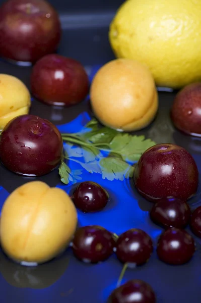 Frutas em água azul closeup — Fotografia de Stock