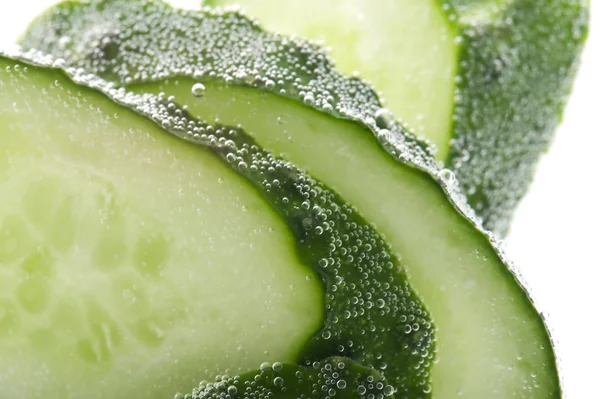 Snijden komkommer in water macro — Stockfoto