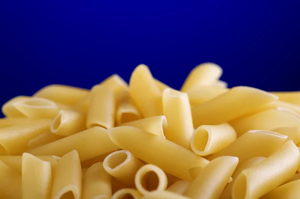 Dry pasta on blue background — Stock Photo, Image